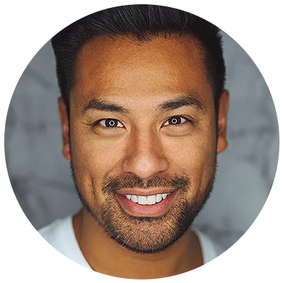 Smiling Asian man with dark hair and beard, looking directly at the camera.